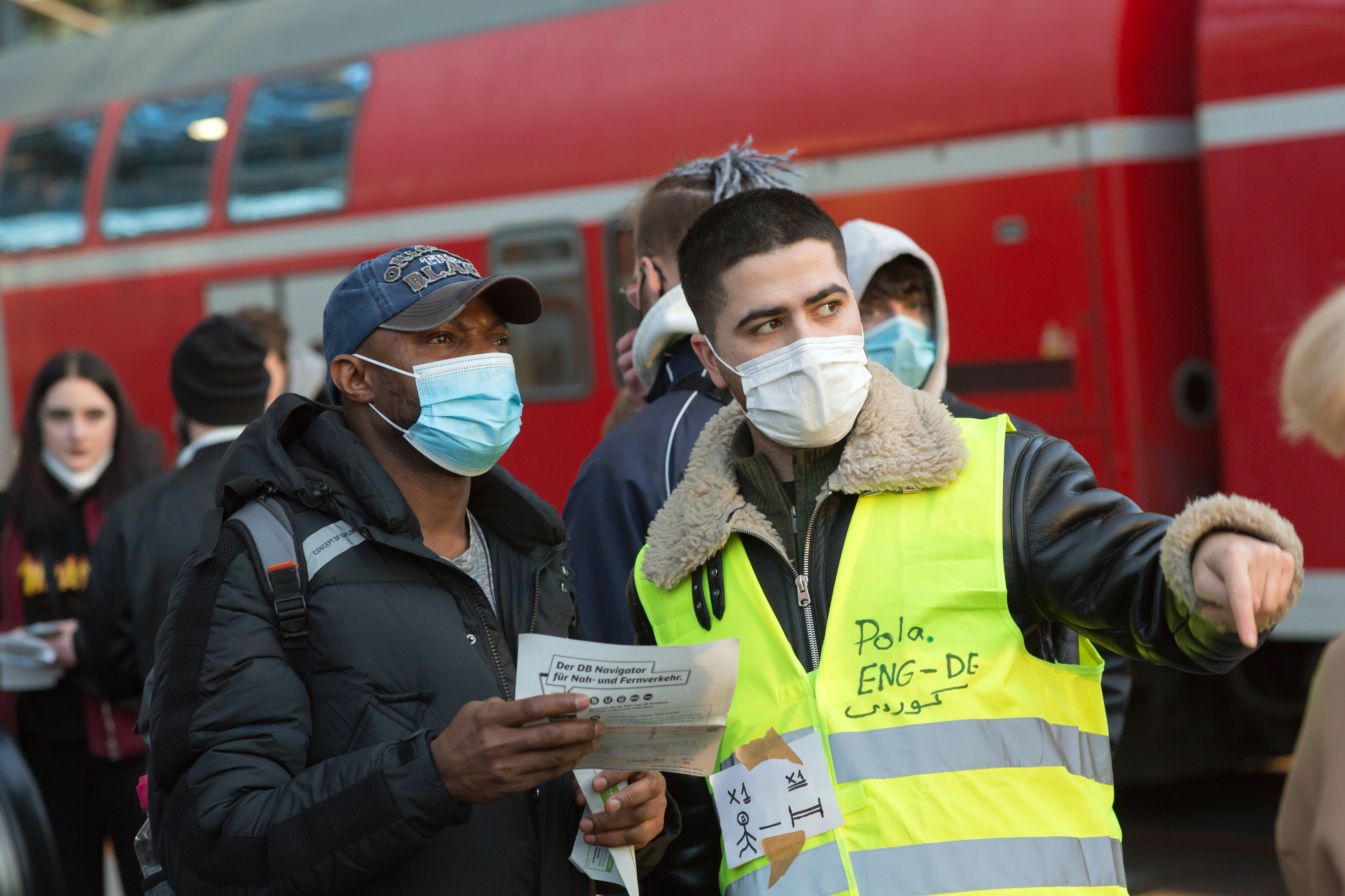 IMAGO / Stefan Trappe | Humanitarian volunteers welcome and help Ukrainian refugees as they arrive at Berlin's Central Station.