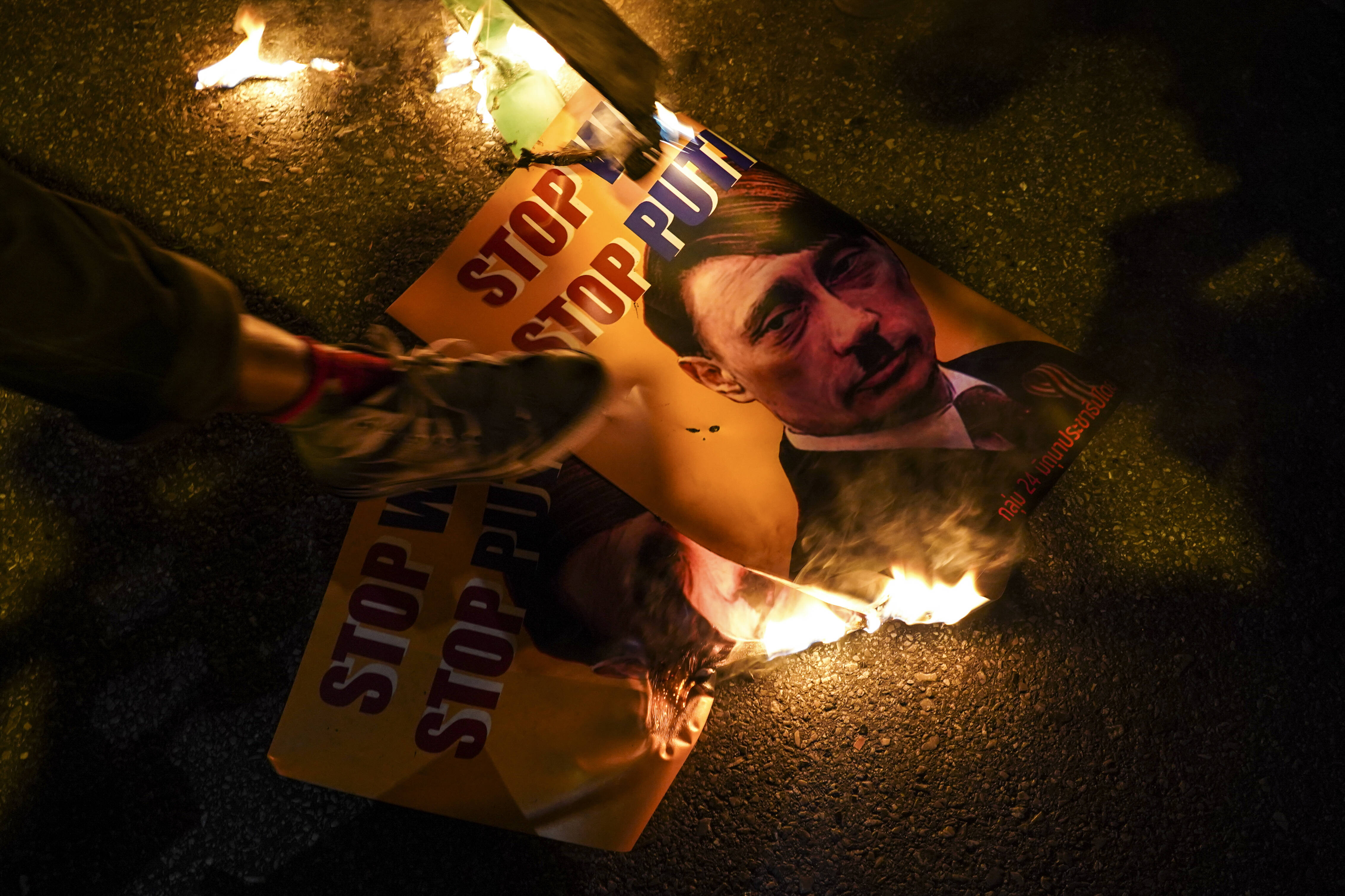 IMAGO / NurPhoto / Anusak Laowilas. 19 March 2022, Bangkok, Thailand. Protesters burn up portraits of President of Russia Vladimir Putin during a demonstration against the invasion.