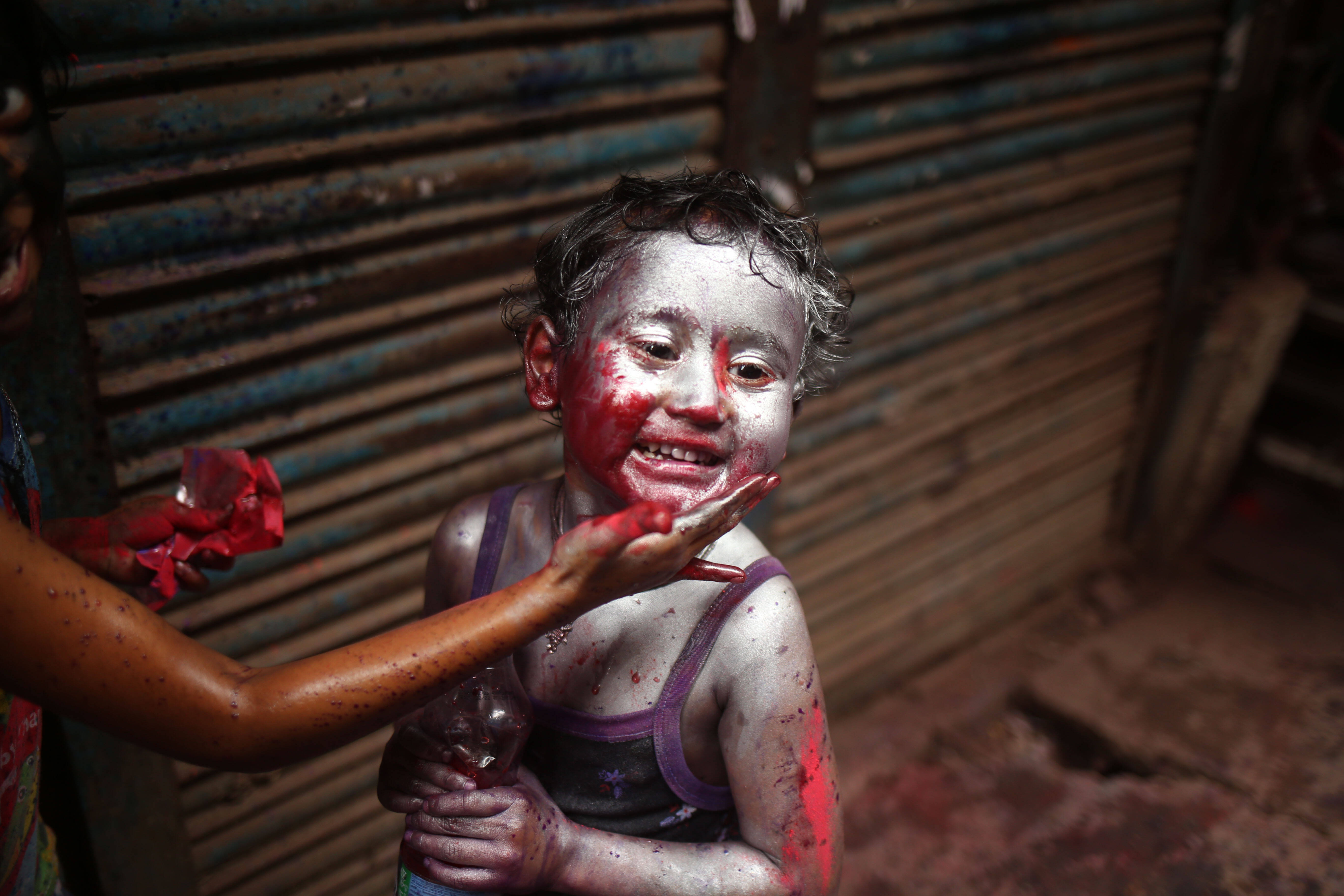 IMAGO / ZUMA Wire / Md. Rakibul Hasan. A child is painted silver as Hindu devotees celebrate Dol Jatra also known as Holi in Old Dhaka, Bangladesh.